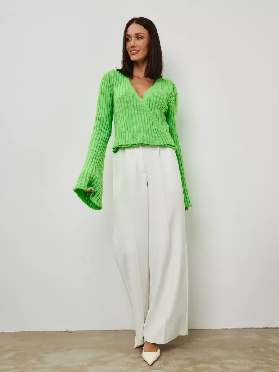 Vega Sweater by Lauven, cropped pistachio knit with deep V-neck and wide sleeves, styled with white pants.