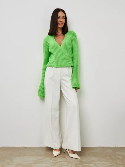 Vega Sweater by Lauven in cropped pistachio knit with V-neck and wide sleeves, styled with white trousers.