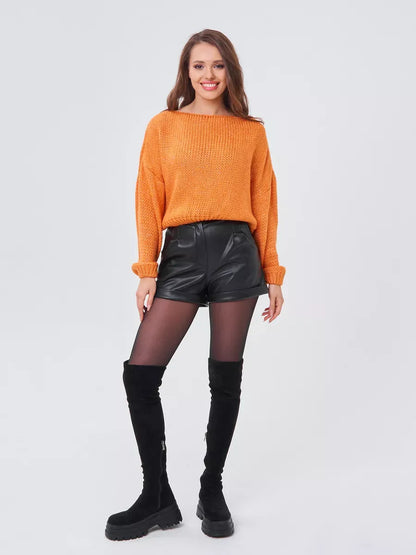 Woman wearing Solara Sweater in orange with black shorts and thigh-high boots, showcasing Lauven's modern, chic style.