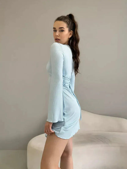Isabella Mini Dress by Lauven in pastel blue, featuring long sleeves, a tie-back, and a flared hem.