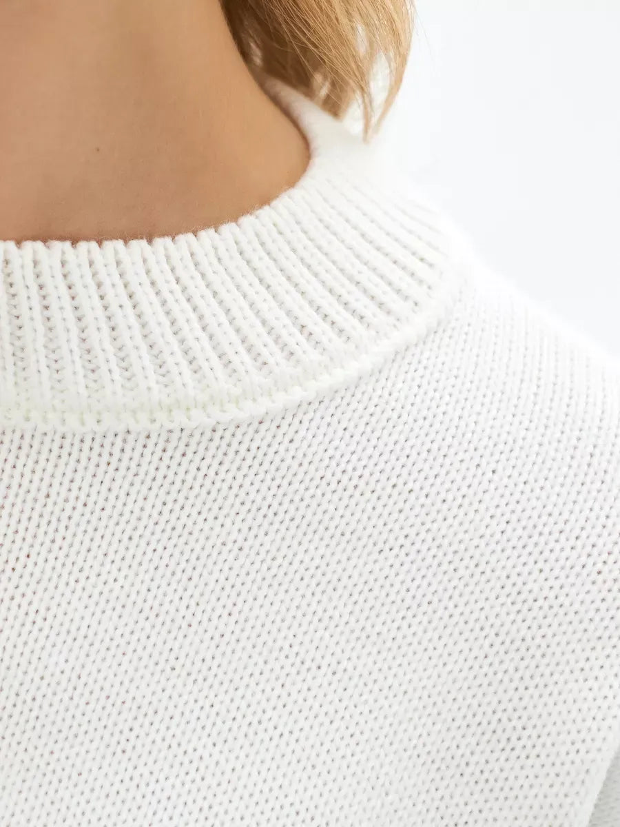 Close-up of the neckline of an Ivory Sweater by Lauven, featuring a textured white knit and ribbed collar.