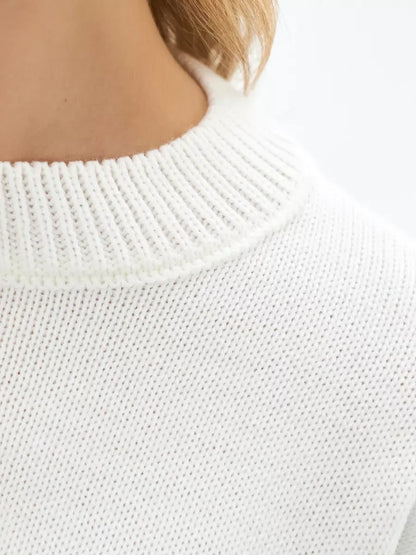 Close-up of the neckline of an Ivory Sweater by Lauven, featuring a textured white knit and ribbed collar.