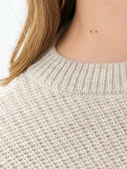 Astra Sweater close-up showing light beige knit texture and round neckline by Lauven.