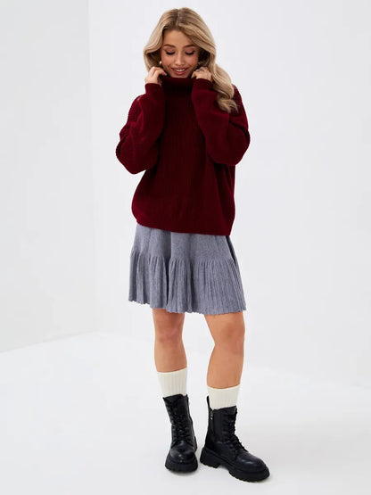 Crimson Pullover by Lauven - Oversized burgundy knit sweater with high neck, styled with a pleated gray skirt.