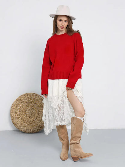 Woman wearing Ember Pullover by Lauven, a bold red oversized cropped sweater, styled with a lace skirt and boots.