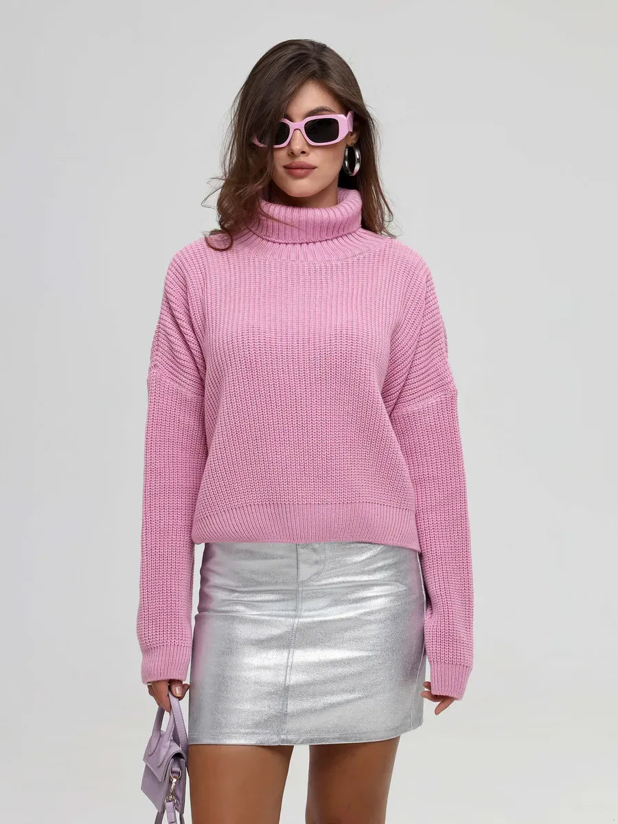 Iris Sweater by Lauven, showcasing oversized knit and turtleneck, styled with a silver skirt and sunglasses.