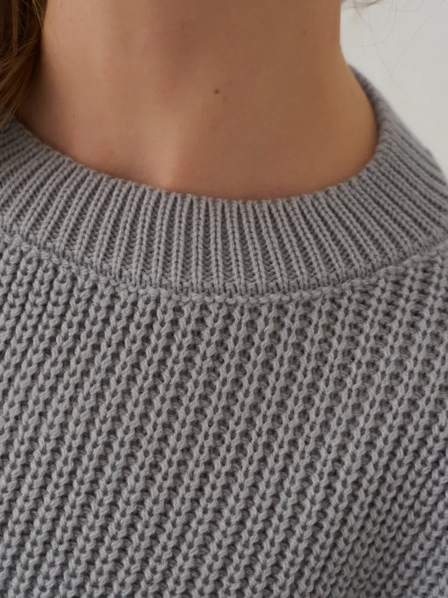 Close-up of the neckline of the Luna Sweater by Lauven in soft light grey knit, showcasing its elegant design.