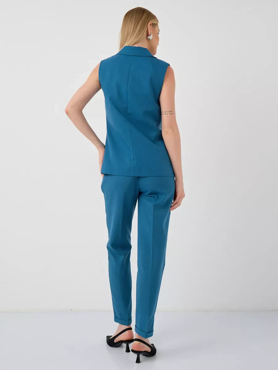 Back view of a woman wearing a Lauven Marine Suit Set with a sleeveless teal vest and high-waist pants.