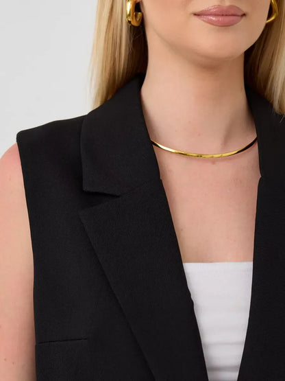 Close-up of a model wearing the Noir Suit Set sleeveless black vest by Lauven, featuring a gold necklace.