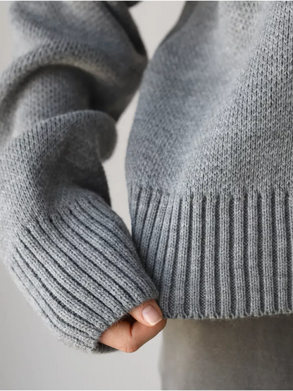 Close-up of the sleeve and hem of the Nova Pullover by Lauven, showcasing its soft silver-gray fabric and ribbed design.