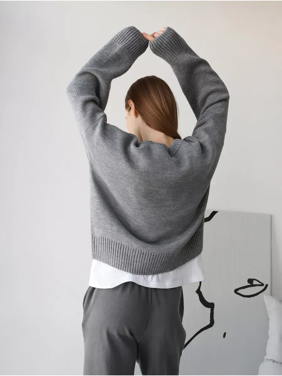 Model wearing the Nova Pullover oversized cropped sweater by Lauven in silver-gray melange from the back.