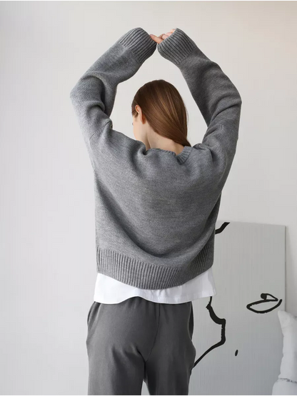 Model wearing the Nova Pullover oversized cropped sweater by Lauven in silver-gray melange from the back.