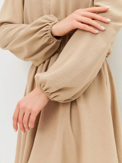 Nude Mini Dress by Lauven featuring elegant off-shoulder design and long sleeves in a soft beige fabric.