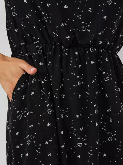 Onyx Mini Dress by Lauven featuring a black fabric with white heart patterns and an elastic waistband for a comfortable fit.