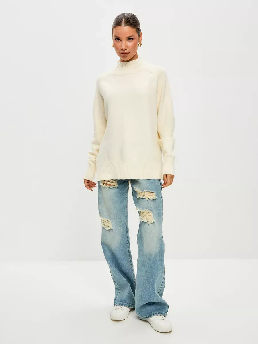 Luna Sweater by Lauven in ivory, oversized cashmere blend with high neck, paired with ripped jeans for a chic look.