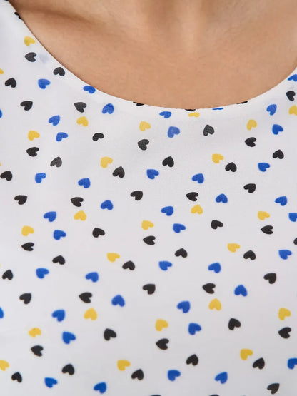 Close-up of Pearl Mini Dress by Lauven featuring a white fabric adorned with colorful heart patterns.