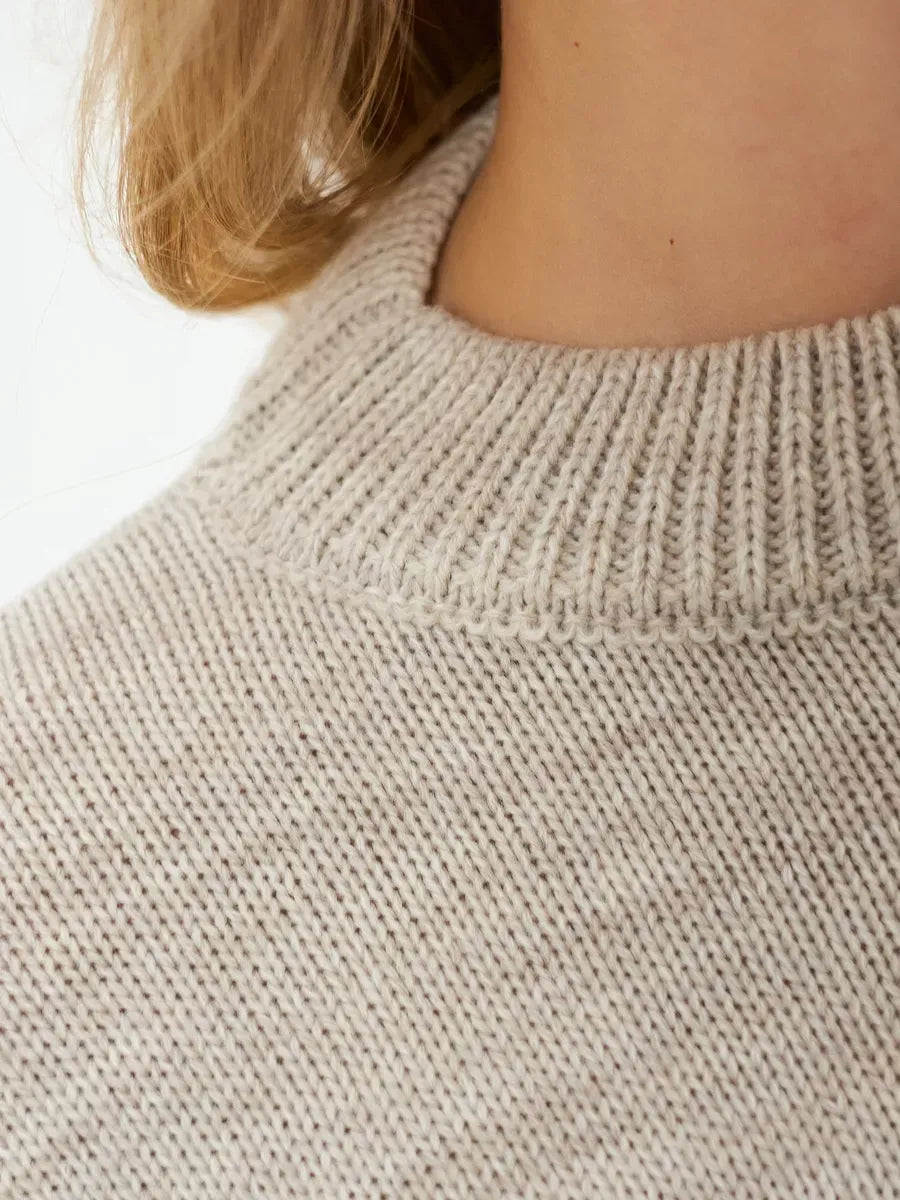 Close-up of the textured collar of the Lauven Sand Sweater, a cropped oversized knit in light beige.