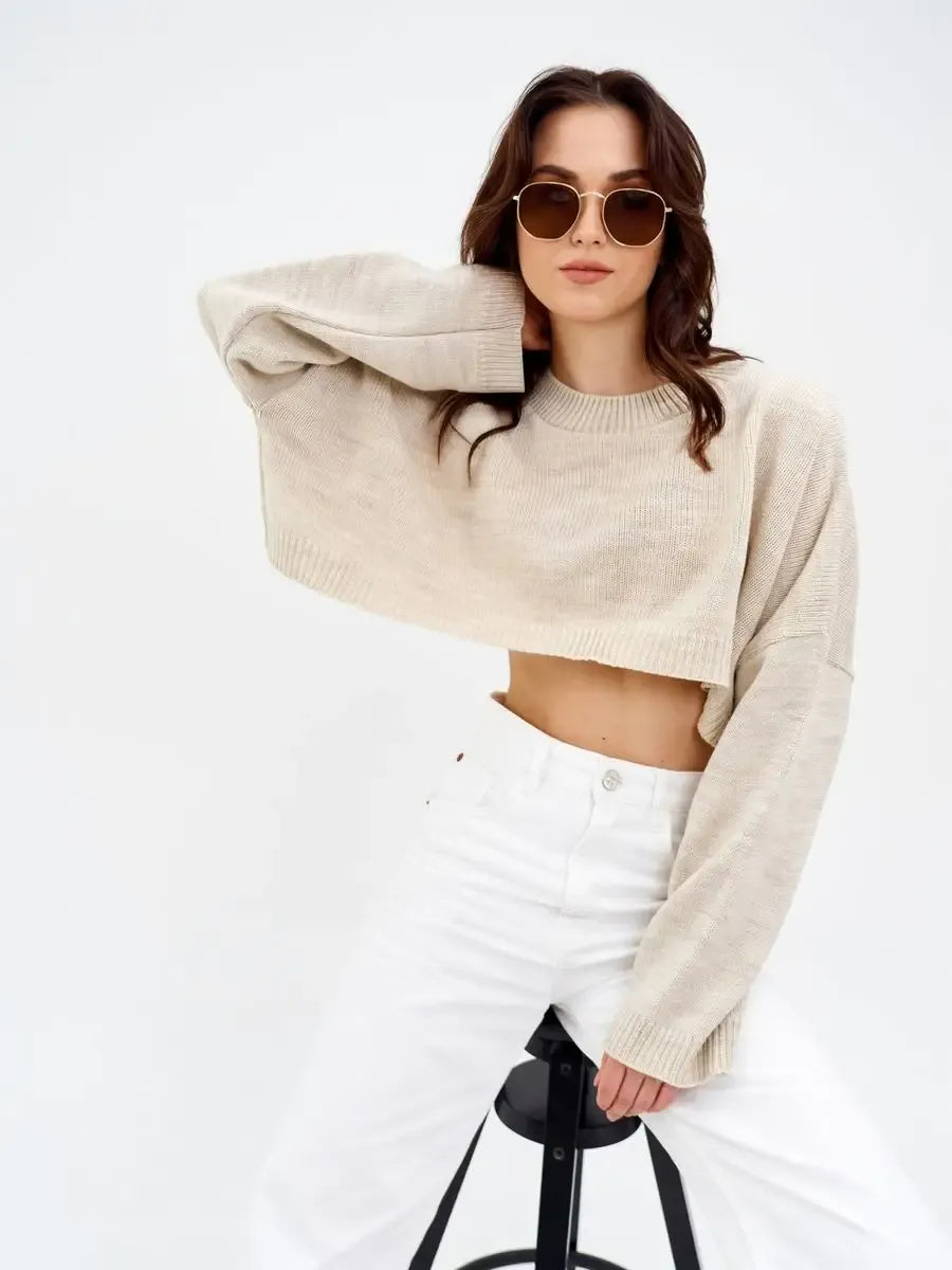 Cropped oversized Sand Sweater in light beige by Lauven, paired with sunglasses and white pants for a stylish look.