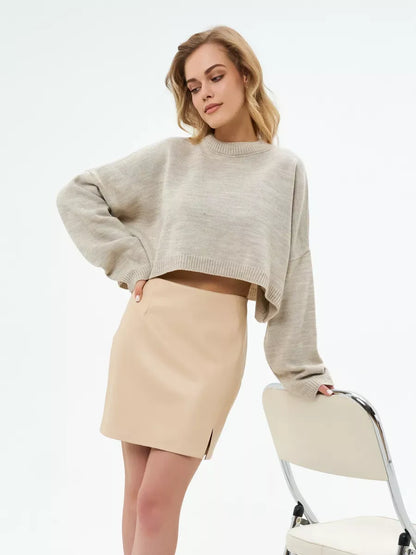 Light beige Sand Sweater by Lauven, cropped oversized knit paired with a beige skirt.