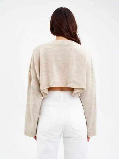 Back view of Sand Sweater by Lauven, a cropped oversized knit in light beige, perfect for layering.