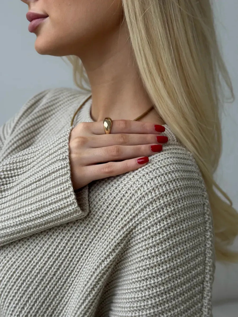 Woman wearing the Sierra Sweater by Lauven, showcasing a cozy beige knit and chic accessories.