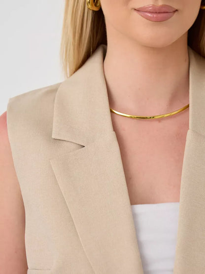 Solara Suit Set by Lauven featuring a sleeveless beige vest with gold accessories.