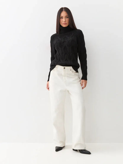 Noir Knitwear by Lauven: Women’s wool-blend turtleneck sweater styled with casual white pants.