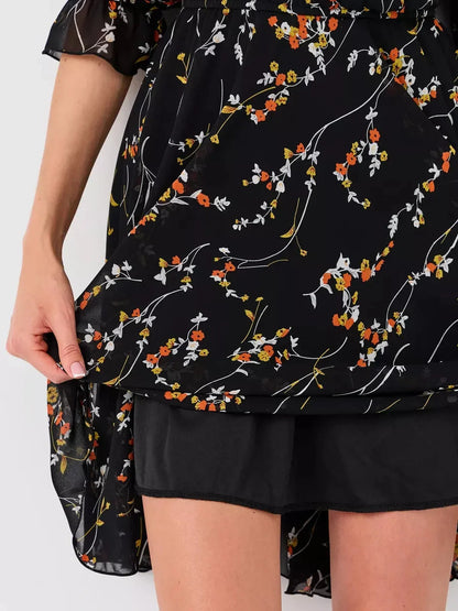 Lotus Mini Dress by Lauven featuring a black floral print and detailed view of the hem.