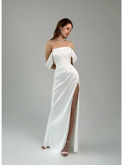 Lyra Occasion Dress by Lauven in white satin, featuring off-shoulder design, draping, and thigh-high slit.
