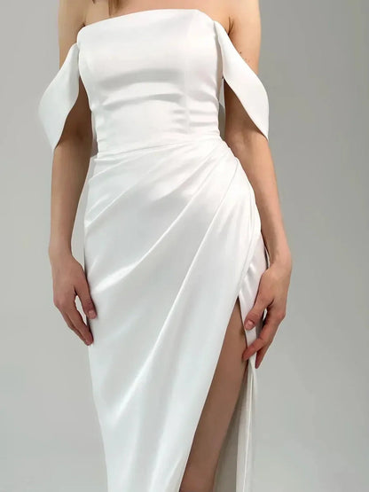 Lyra Occasion Dress by Lauven – Elegant off-shoulder white satin gown with draping and thigh-high slit.