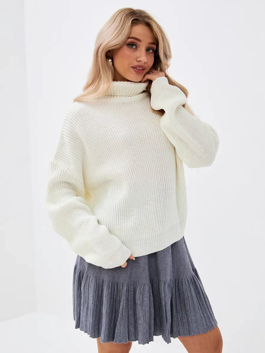 Model wearing Lyra Sweater by Lauven, an oversized knit in ivory with high neck style.