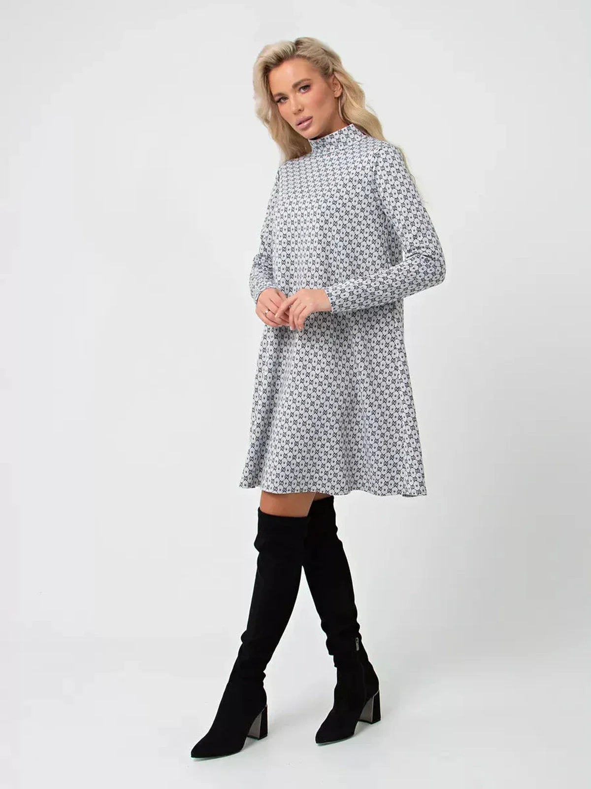 Lauven Maia Mini Dress in graphite grey print, A-line silhouette, long sleeves, and stand collar, styled with knee-high boots.