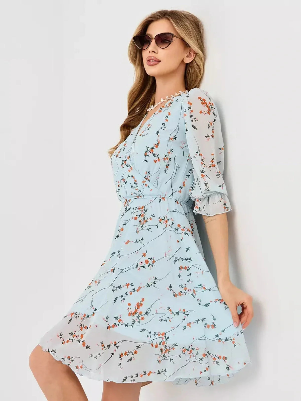 Mara Mini Dress by Lauven, light blue floral wrap dress with V-neckline and 3/4 sleeves.