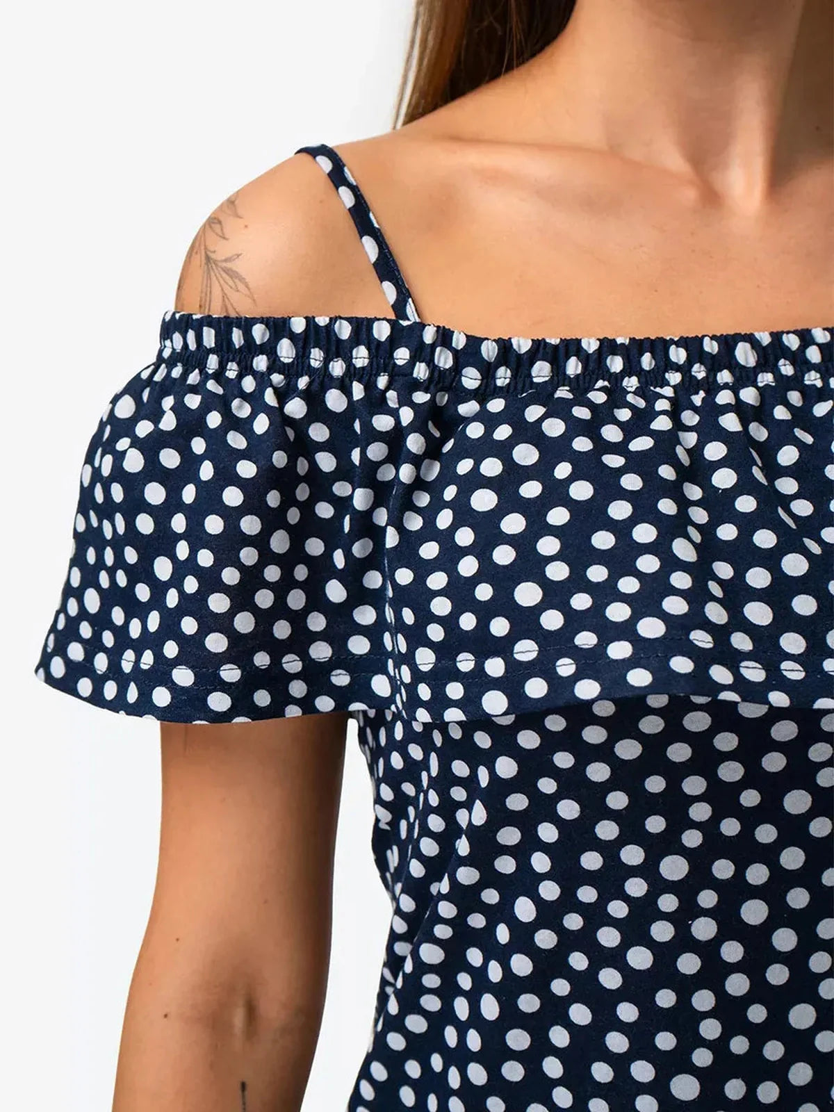 Close-up of Lucy Mini Dress by Lauven featuring navy polka dot cotton off-shoulder ruffle detail.