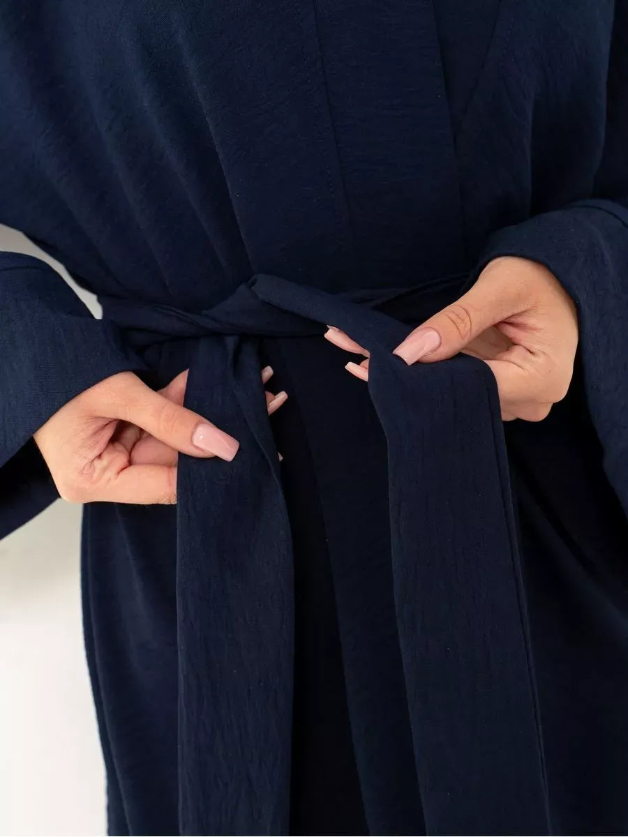Model adjusting the belt of the Navy Suit Set by Lauven, showcasing the sophisticated deep blue fabric.