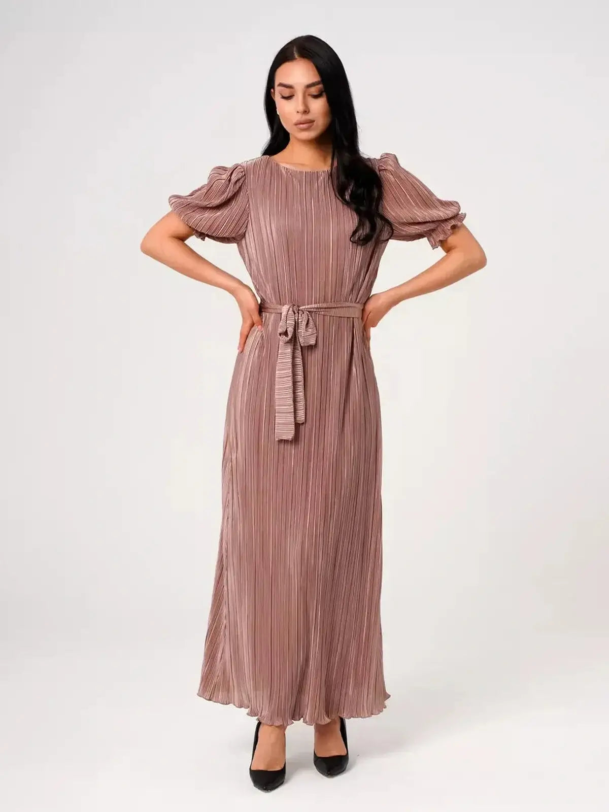 Model wearing Noa Maxi Dress with elegant pleats and puff sleeves in light cappuccino color.