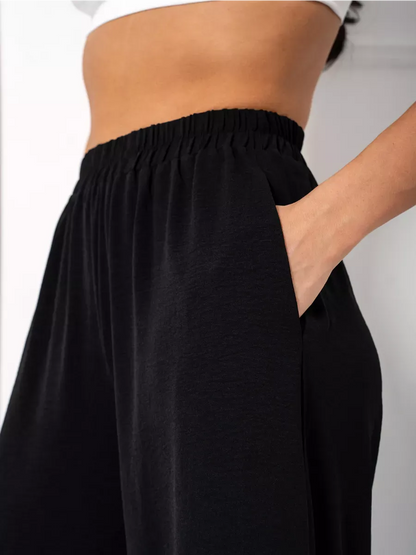 Close-up of the wide-leg trousers from the Noir Suit Set by Lauven, featuring a comfortable design with pockets.