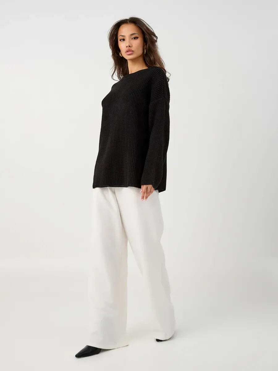 Nola Sweater by Lauven, oversized black knit pullover with crew neck, styled with white trousers.