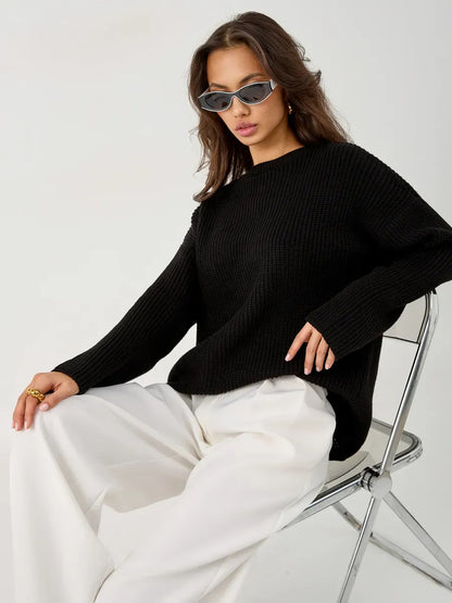 Nola Sweater by Lauven - Oversized black knit pullover styled with relaxed white trousers and chic sunglasses.
