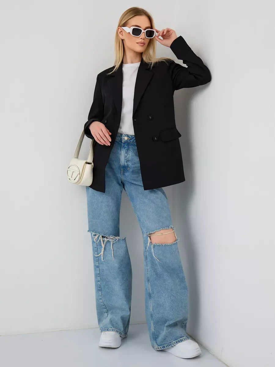 Model wearing the Nova Blazer by Lauven, a sleek oversized black double-breasted blazer, styled with casual jeans.