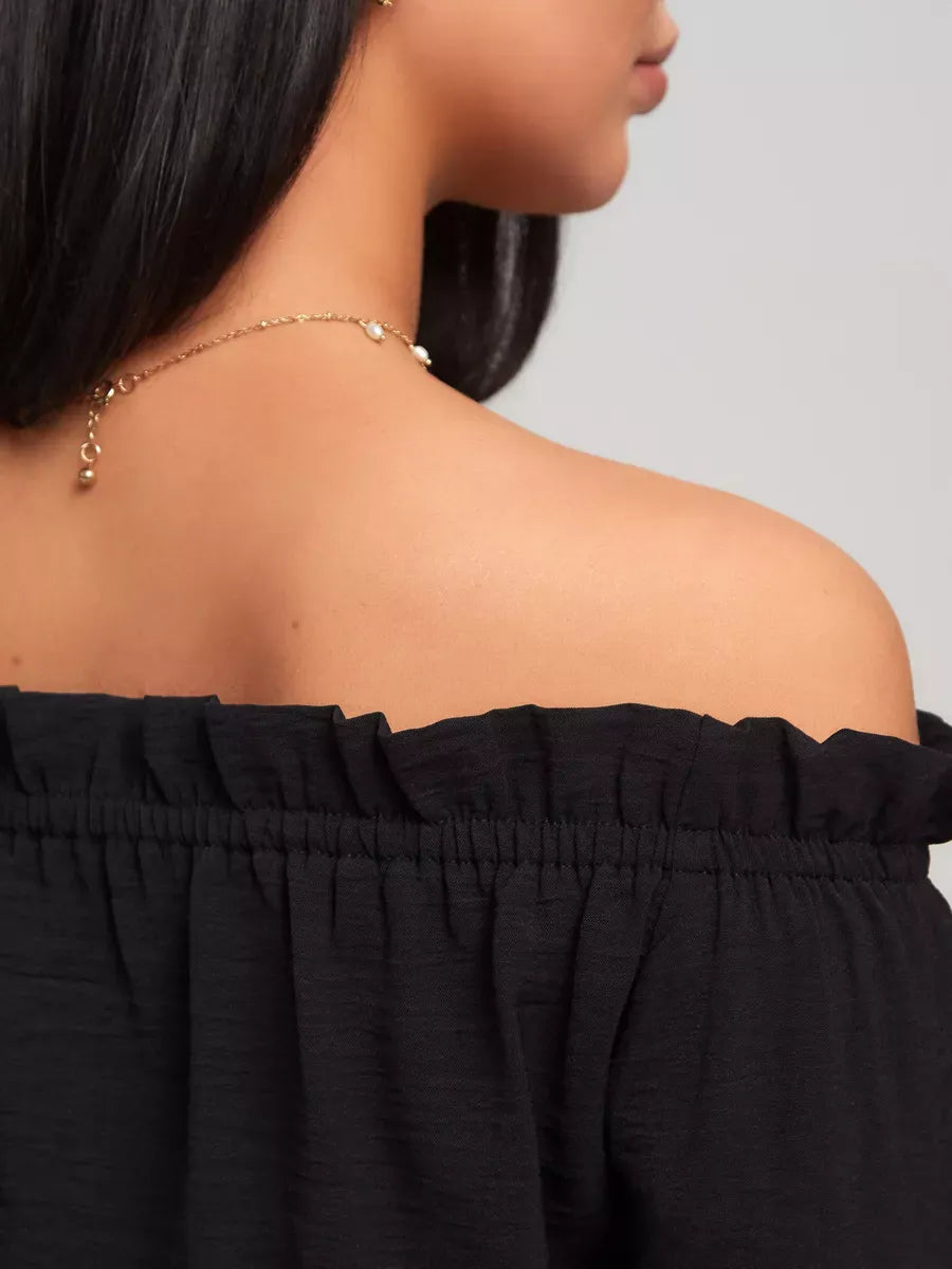 Detail of the Nova Mini Dress showcasing off-shoulder design and elegant neckline by Lauven.