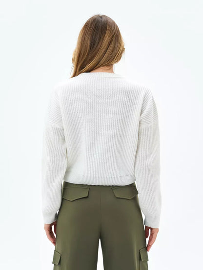 Back view of a woman wearing the Nova Sweater by Lauven, showcasing its white rib-knit design and relaxed fit.