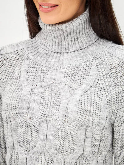Close-up of a woman wearing the Osiris Sweater by Lauven, showcasing the oversized cable knit design and high turtleneck.