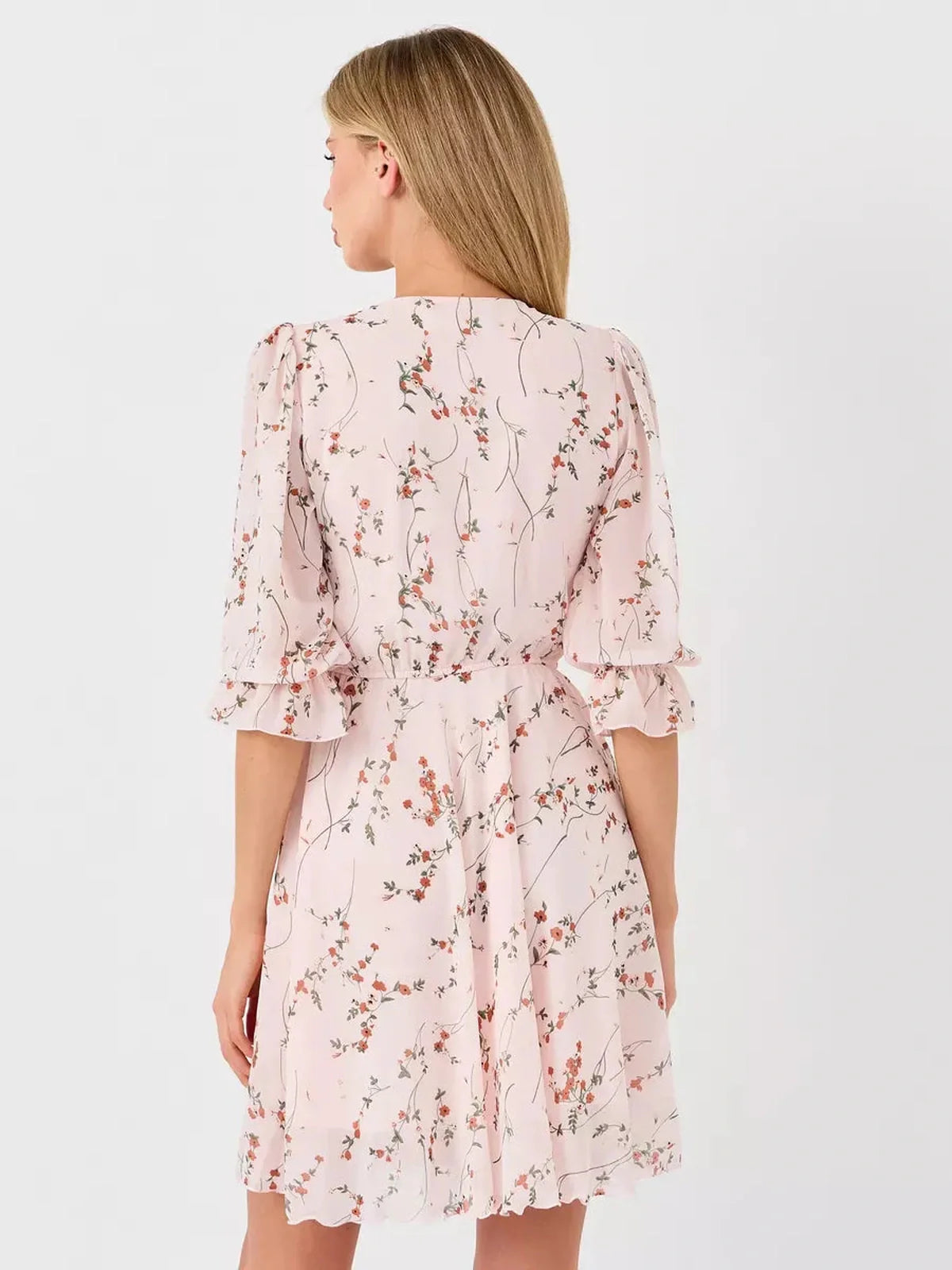 View of the back of the Primrose Mini Dress by Lauven, featuring a pink floral print and ruffled sleeves.