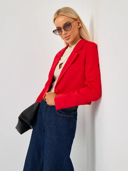 Model wearing Lauven Ruby Blazer, a cropped tailored red blazer, styled with sunglasses and wide-leg jeans.