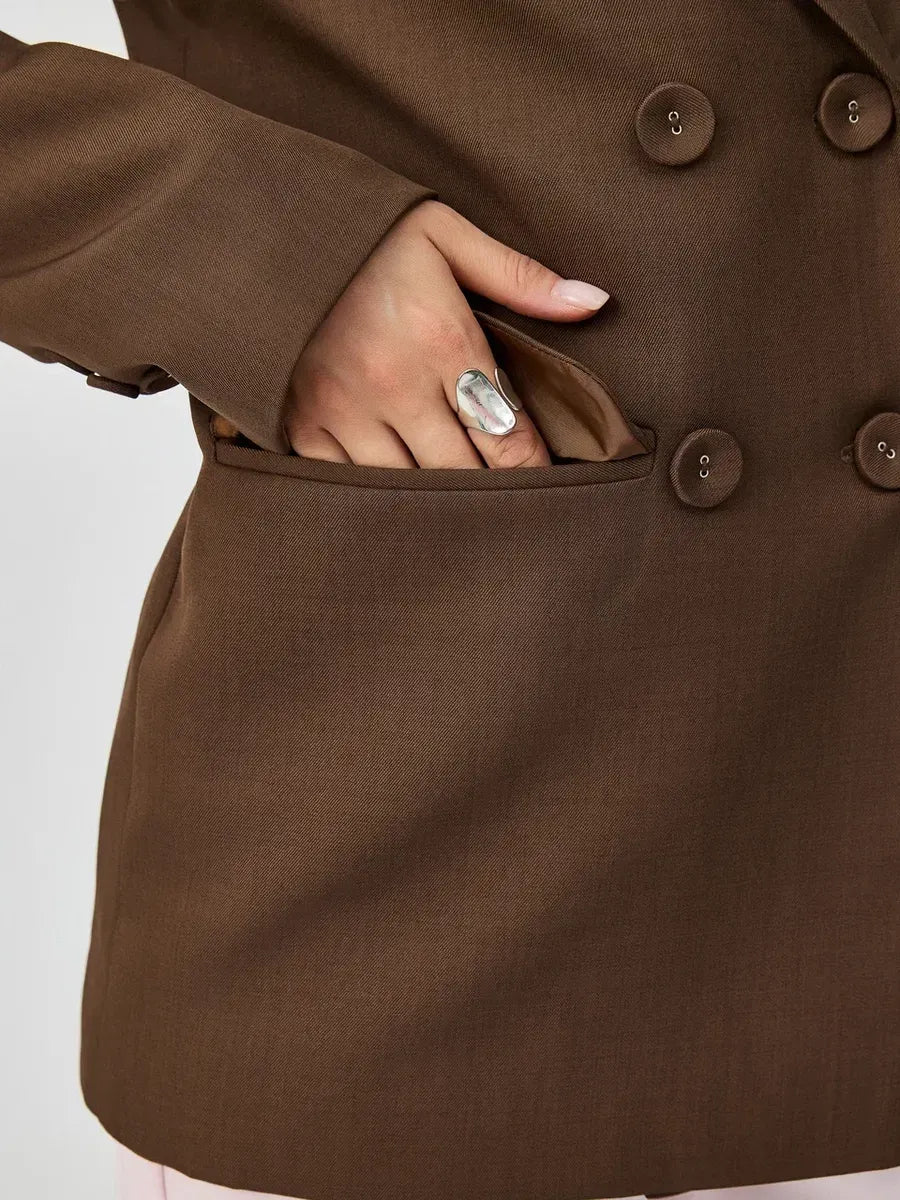 Model showcasing the Saffron Blazer by Lauven, featuring a chocolate oversized double-breasted design.