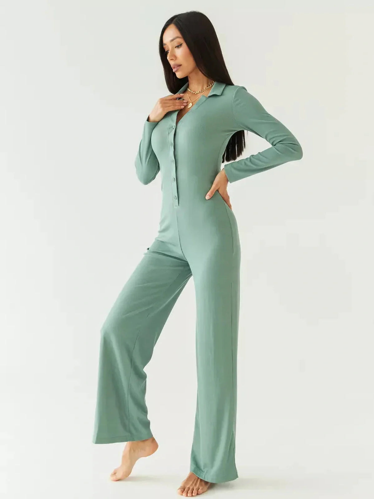 Model showcasing the Scarlett Jumpsuit in sage green, featuring a fitted bodice, button-down front, and wide-leg silhouette.