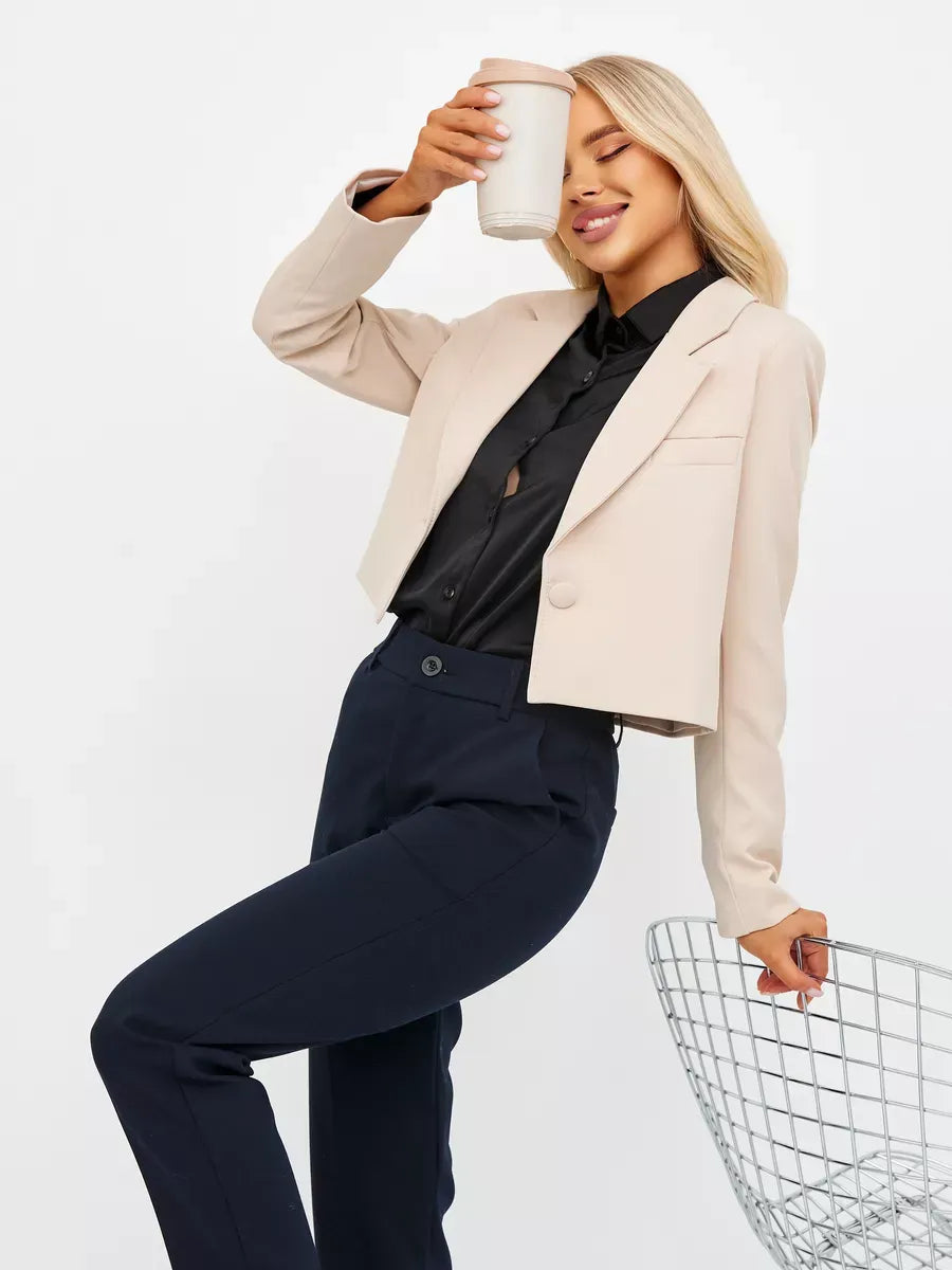 Model wearing a Sandstone Blazer from Lauven, showcasing a soft beige cropped silhouette with black shirt and pants.