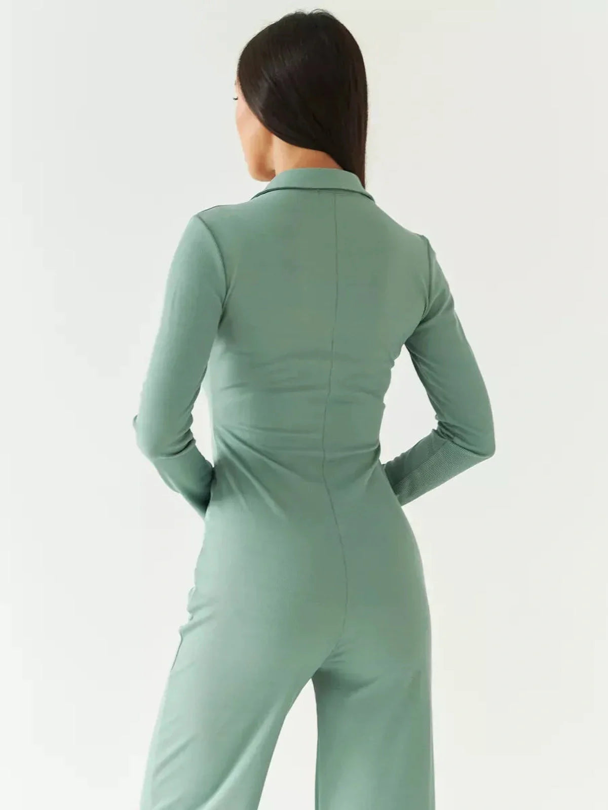 Back view of a model wearing the Lauven Scarlett Jumpsuit in sage green, featuring a structured collar and long sleeves.