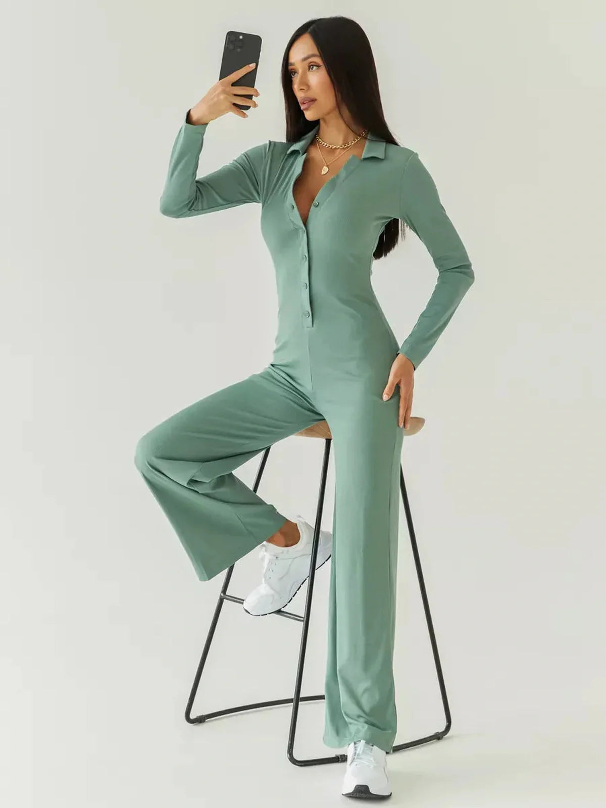 Model wearing the Scarlett Jumpsuit in sage green, showcasing ribbed knit fabric and a wide-leg silhouette.